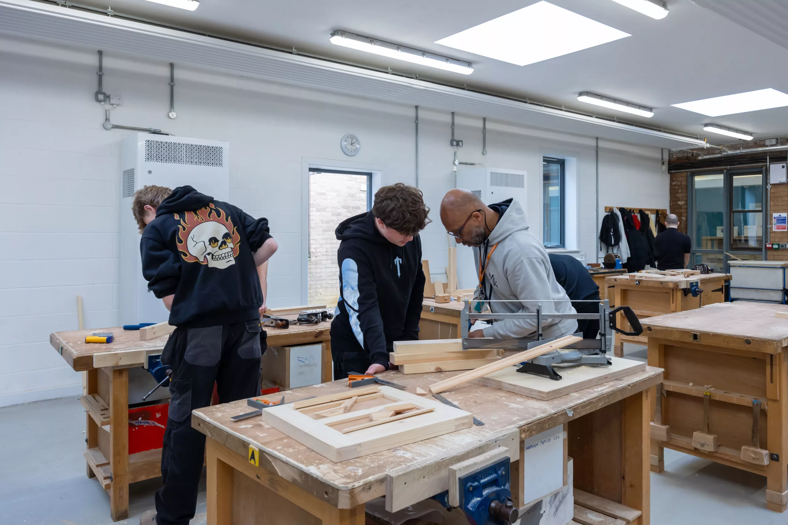 Construction students working on a wooden structure – Apprentices practising carpentry skills in a workshop.