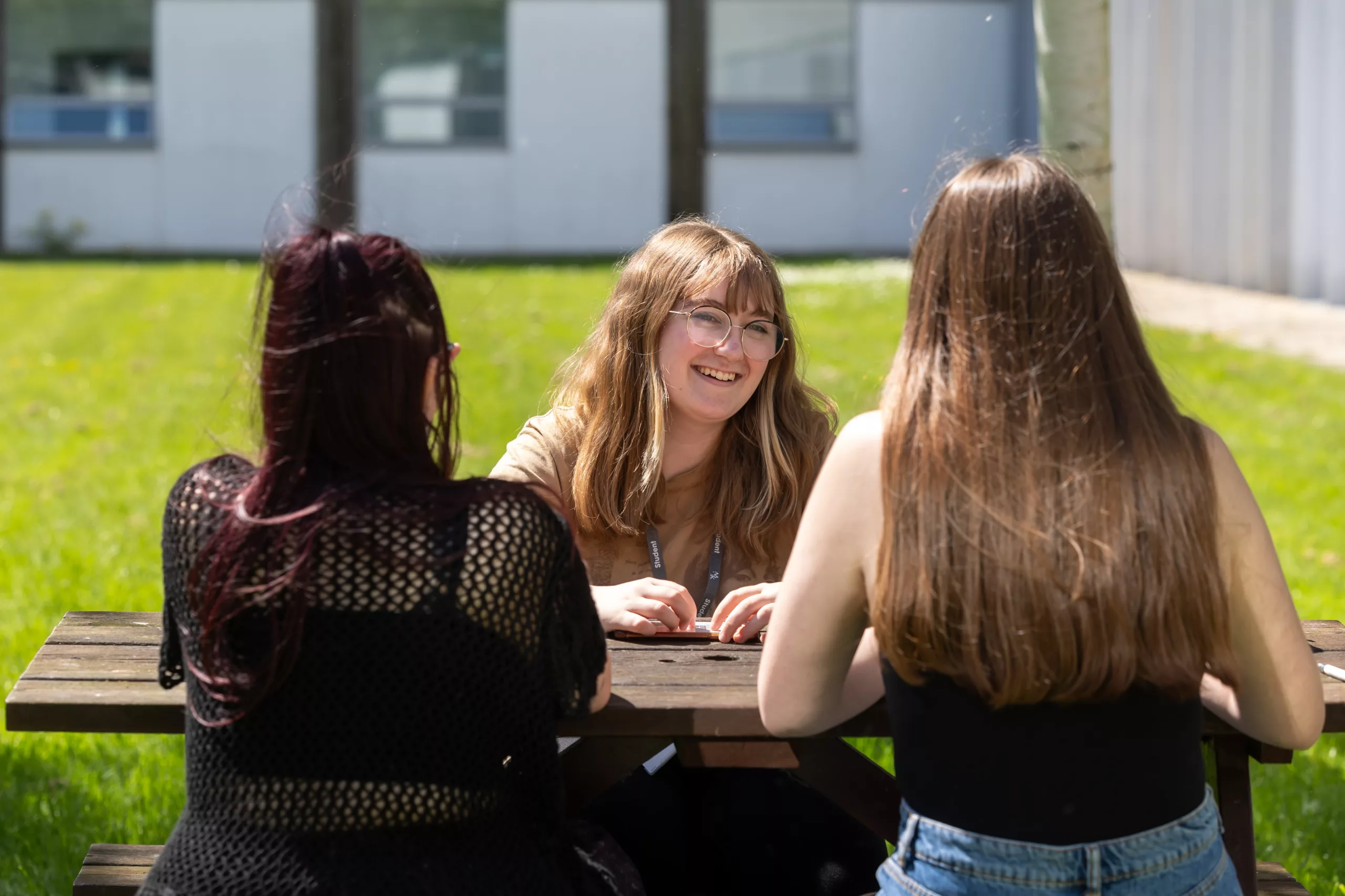 A group of students sitting outdoors at a table, studying together.